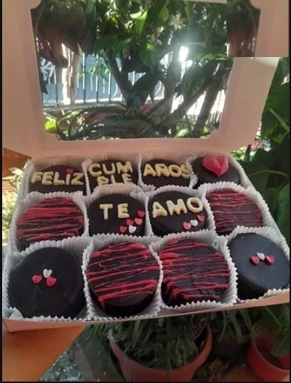Caja de alfajores con la palabra Feliz Cumpleaños y Te amo escrita en chocolate